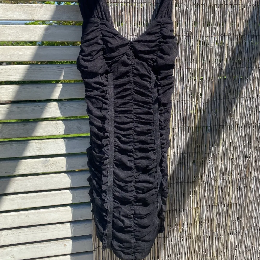 Säljer denna jättefina svarta scrunch klänningen med fina detaljer.  Köpt för 500kr. Klänningar.