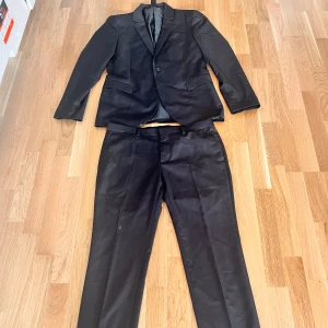 Kavaj + kostymbyxor  - Kostym från Kiomi  Storlek 48 på båda Använda 1 gång Inga slitskador, men hag en liten fläck på kavajen nere höger (visas på bild)