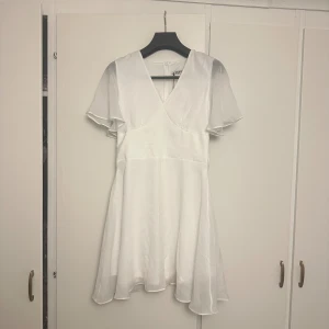 Student klänning  - Säljer denna superfina vita klänning från NAKD💕Helt oanvänd med prislapp kvar. Den har en defekt som man kan de på sista bilden som den kom med när jag fick hem den, men det är enkelt fixat och dessutom syns det knappt💕💕💕