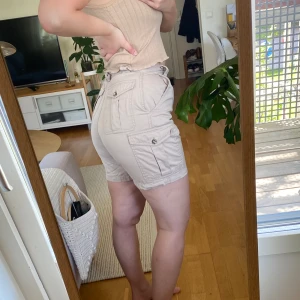 Cargoshorts - Högmidjade cargoshorts i storlek 36 som tyvärr blivit lite för små för att jag ska vara bekväm i dem. Många fickor och fint skick!