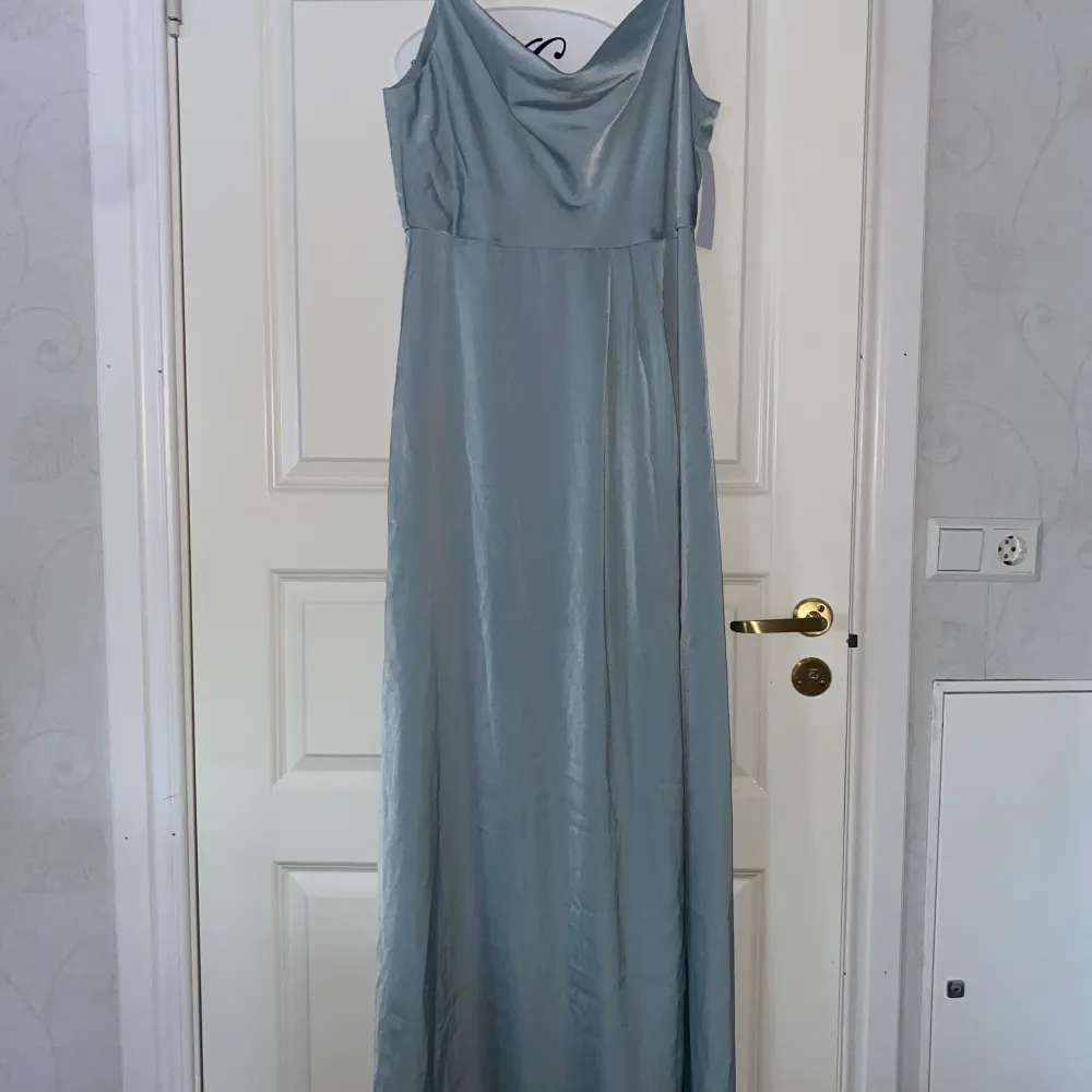 Balklänning strl 42 (liten i storleken) klänningen är i satin och färgen är grön men ser lite blå ut på bilden Aldrig använd. Klänningar.