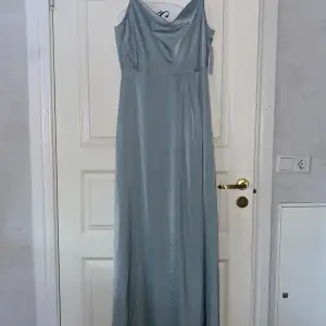 Balklänning strl 42 (liten i storleken) klänningen är i satin och färgen är grön men ser lite blå ut på bilden Aldrig använd