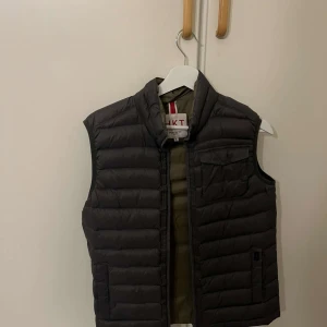 Grå Hackett london väst  - Säljer min grå väst i st S. Den är även oliv grön inne. Har endast använda ett par ggr utöver det är den helt ny och även nyskick. 