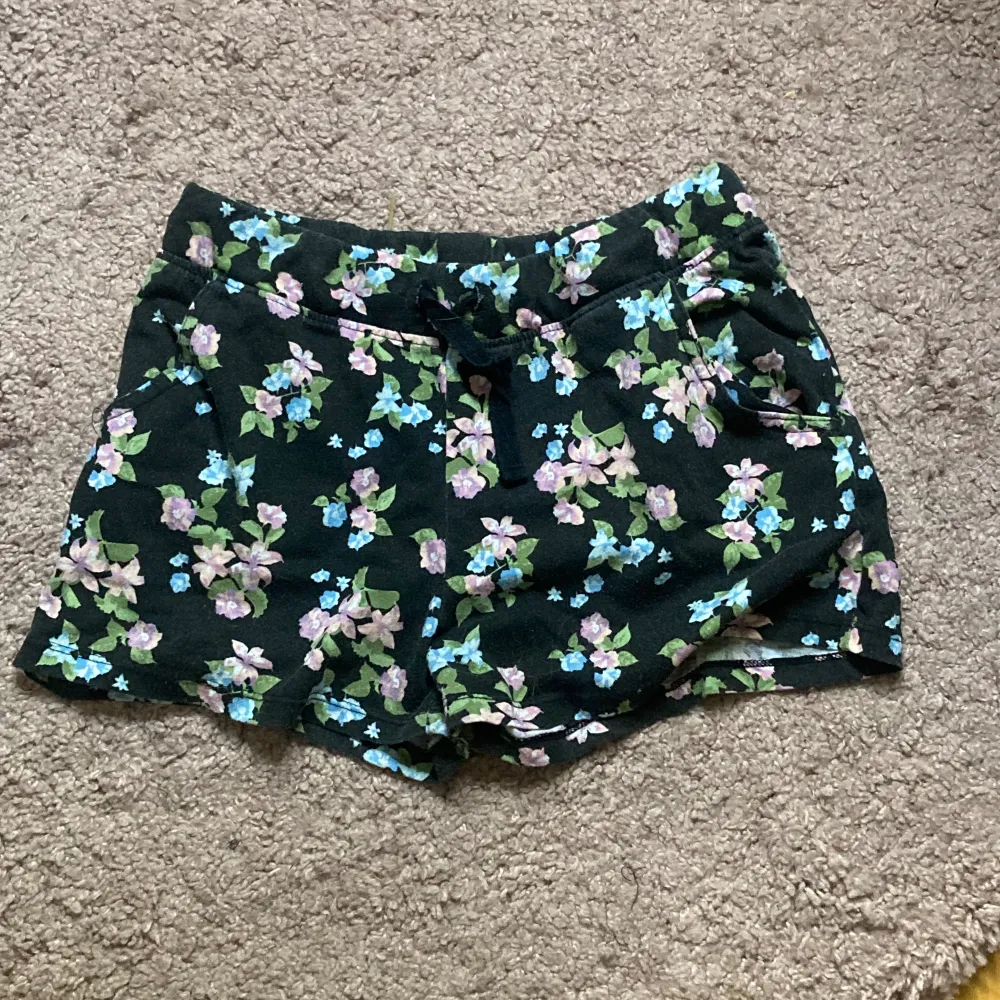 Det är ett par blommiga shorts i storlek 158-164, men jag kan tycka att de känns större än så. De är från Basic U och är bara använda ett fåtal gånger, de är i mycket bra skick. . Shorts.