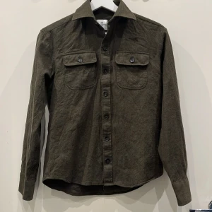 John Henric Overshirt  - Säljer denna militärgröna John Henric Overshirt då den är för liten på mig. Skick: 9/10 (Använd endast 2 gånger)