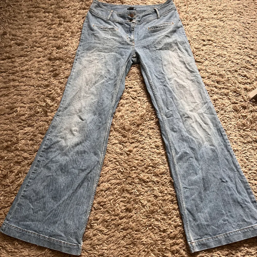 Jättefina ljusblåa jeans (vintage H&M), superbra skick! Storlek 38, bootcut/vid modell🙏🏼 Midjemått: 40 cm rakt över Innerbenslängd: 83 cm Bredd längst ner: 29 cm rakt över. Jeans & Byxor.
