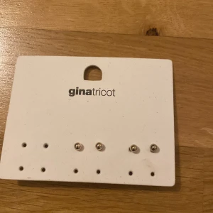 Två örhängen  - Två örhängen i brons och guld från Gina tricot, aldrig använda eller testade, kontakta oss vid köpa av en 