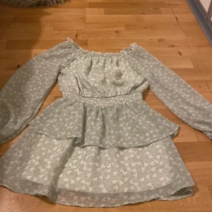 Grön klänning med blommor  - Grön klänning med vita blommor på från Kappahl, bra skick använd 3 gånger, original pris 300kr