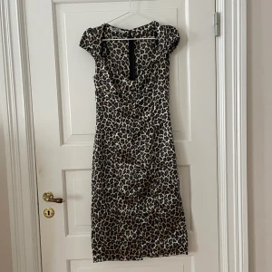 Leopardklänning  - ”Siden” klänning i leopard. Storlek 38 men liten i storlek så passar nog mer 34-36. Dragkedja och slits baktill. Aldrig använd, i nyskick. Bara att fråga om det är något du undrar!
