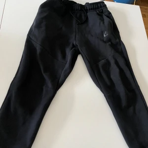 Nike tech byxor  - Svarta Nike tech byxor i ett okej skick är i storlek XL i BARNSTORLEK (158-170cm)