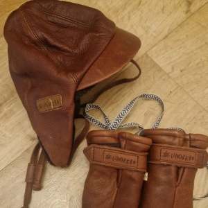 Lindberg mössa och vantar - Superfint set av mössa och vantar i älgskinn. Storlek 44 på mössan och inga tummar på vantarna.