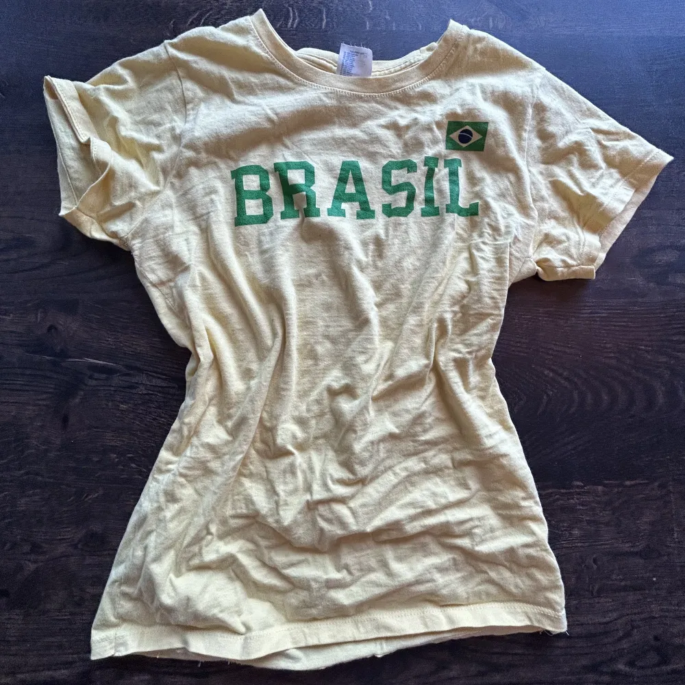 Säljer denna jättefina gul och gröna Brasilien tröjan. Den har två små fläckar som ni kan se på andra bilden, men de syns knappt. Storlek S skulle jag säga . T-shirts.
