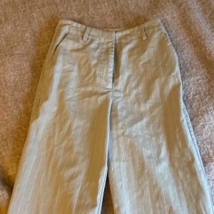 Kostymbyxor - Beiga kostymbyxor storlek 34. Sparsamt använda. Bra skick. Bootcut modell. Jag är 175, aningens korta på mig.