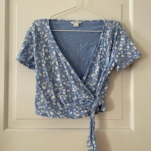 Omlotttopp från Monki - Omlott t-shirt från Monki i storlek S. Använd ett fåtal gånger, i fint skick. Bara att fråga om det är något du undrar! Kan mötas på Järntorget i Göteborg eller skicka, köparen står för frakt.