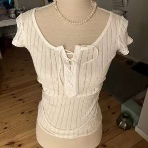 Topp coquette - Söt coquette topp som är lite genomskinlig och figursydd med snörning framtill. Helt oanvänd men köpt på HM LOGG för många år sedan .