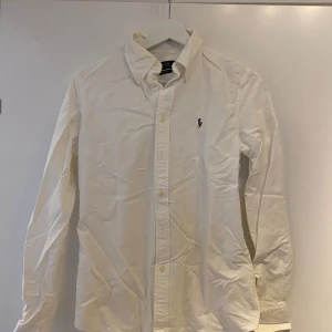 Ralph Lauren Skjorta - Jättefin vit skjorta från Ralph Lauren. Använd 2ggr och tvättad en gång (därav skrynklig då den legat i en klädpåse efter tvätt) ord.pris ca 1400kr mer eller mindre