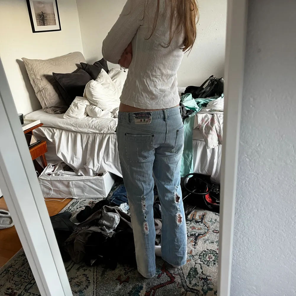 Lågmidjade bootcut jeans med hål på bak och framsida. Så coola detaljer, passar S💕. Jeans & Byxor.