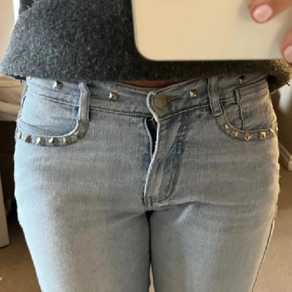 Jättefina lågmidjade jeans med nitar!🤍 lite trasiga längst ner på byxan. Jeans & Byxor.