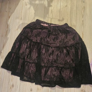 Rosa svart kjol - Svart kjol med rosa under! Är stl xl men skulle nog kunna användas av en storlek större då den är stretchig!