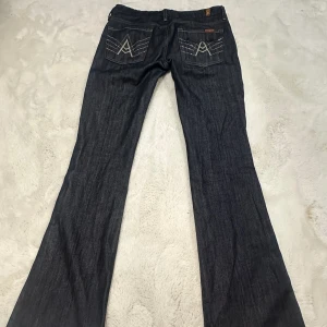 Långa Lågmidjade jeans - Säljer ett par skitsnygga Lågmidjade jeans från märket 7 for all mankind!💙de har glittriga bakfickor och utsvängda ben.  De passar oss längre tjejer då innerbenslängden är 87cm, midjemåttet är 40cm. De är relativt strechiga!✨💙 nypriset var 3000kr