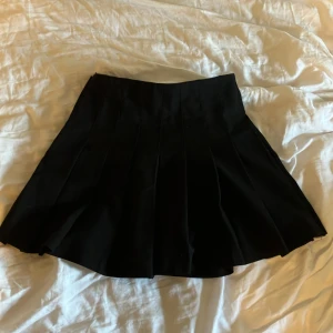 Svart kortkjol från H&M Divided - Säljer en svart kortkjol från H&M i storlek EUR 32 (XXS/XS). Kjolen är i nyskick och har en klassisk A-linjeform som passar perfekt till både vardag och fest. Den är gjord av ett mjukt och bekvämt material som gör den skön att bära hela dagen. orginal pris 299kr