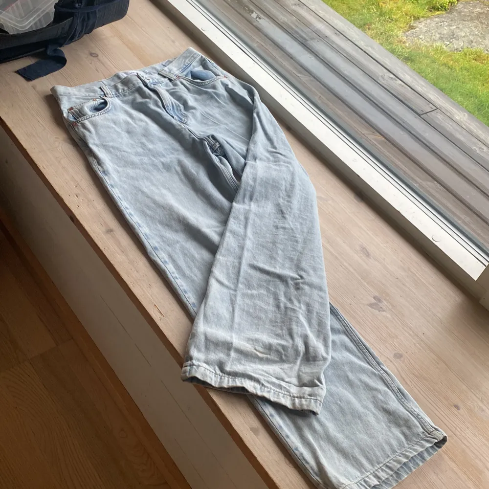 Säljer ett par ljusblå jeans från Junkyard i storlek M. De är i bra skick och har en klassisk femficksdesign med knapp och dragkedja framtill. Perfekta för en avslappnad vardagslook!. Jeans & Byxor.