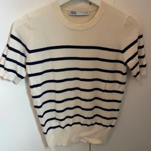 Finstickad t-shirt  - Cremevit med marinblåa ränder. Skönt och mjukt material