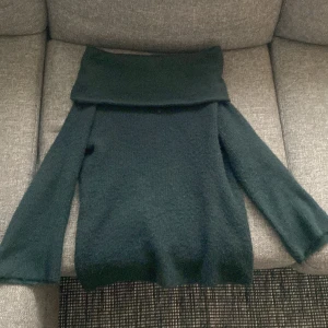 Stickad offshoulder tröja  - Fin och skön stickad tröja! Använd max 5 gånger och i fint skick! Jättefin mörkgrön färg. Tröjan är oversized. 