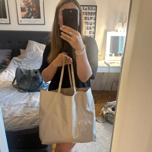 Lackad shopper ifrån hm - Säljer denna supersnygg väskan ifrån hm. Passar till allt! Snygg och i fint skick.