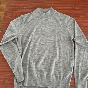 Uniqlo ull tröja (mock neck) - En perfekt grå ull tröja med en mock neck. Skick 9/10. Använt fåtal gånger. Storlek S.