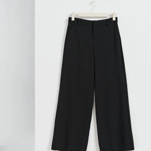 Svarta kostymbyxor - Säljer ett par stilrena svarta kostymbyxor. De är högmidjade och har en rak passform som ger en elegant look. Perfekta för både kontoret och festliga tillfällen. Byxorna är tillverkade i ett bekvämt och hållbart material som känns skönt mot huden. De har en dragkedja och knappar framtill för enkel på- och avtagning.