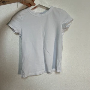Vit kortärmad t-shirt - Säljer en enkel och stilren vit t-shirt i storlek S. Den är kortärmad och gjord av mjukt bomullsmaterial. Perfekt basplagg för alla tillfällen! 💫 En gammal favorit som tyvärr är för liten nu