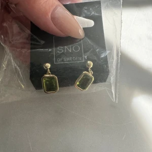 Nya örhängen från SNÖ - Nya i förpackningen  Örhängen från snö of sweden i 18k förgyllt silver med olivgrön sten