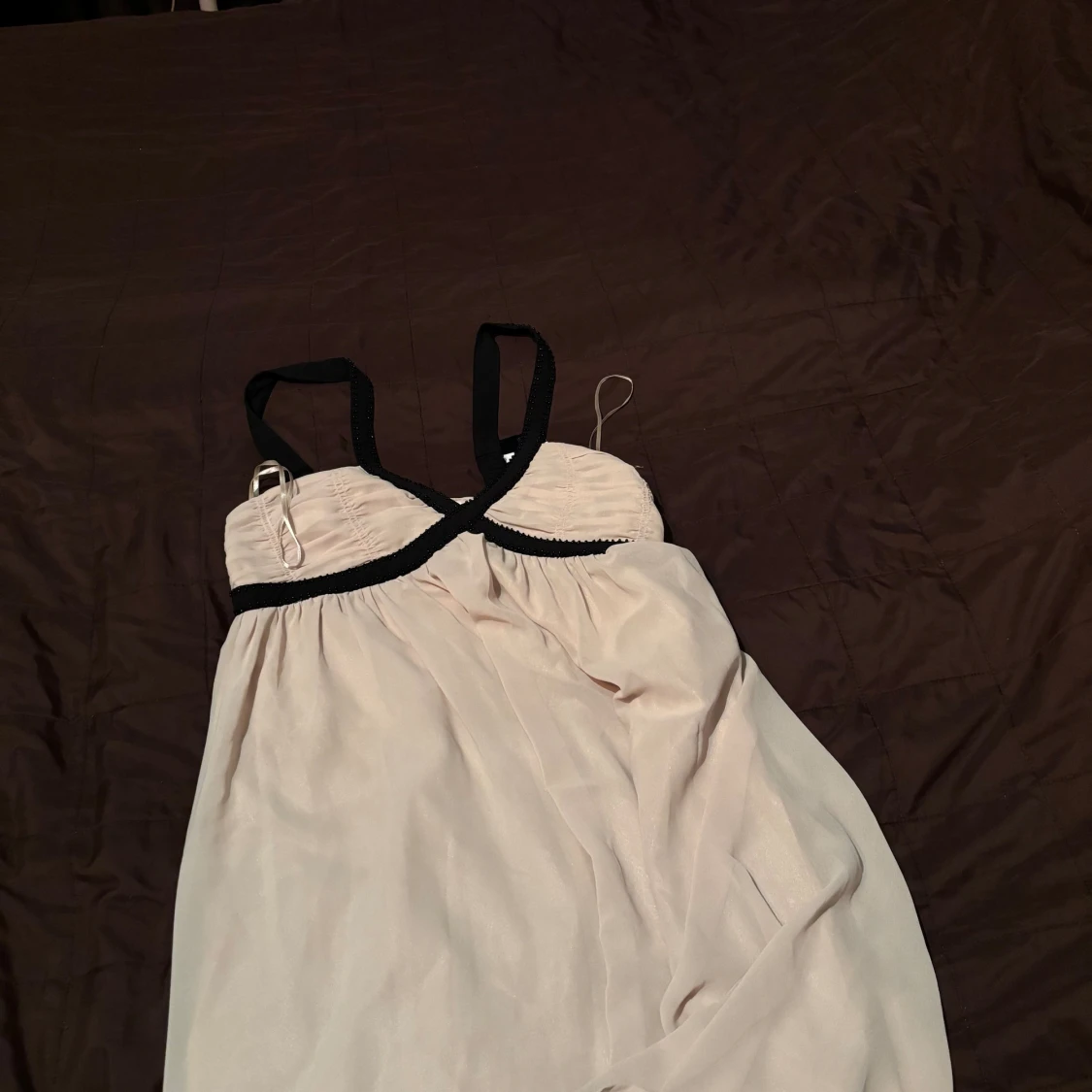 Beige klänning med svarta diamanter på axlarna