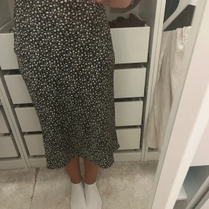 Blommig kjol - Jag säljer en jätte fin svart kjol med blommor på. Kjolen är i fint skick. Storlek xs/s 💗