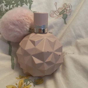 Ljusrosa parfymflaska med fluffig boll - Säljer en superfin ljusrosa parfymflaska från Ariana Grande. Flaskan har en cool geometrisk design och kommer med en fluffig rosa boll som dekoration. Korken är också ljusrosa men har lite slitage på färgen. Perfekt för dig som älskar söta och unika parfymer! 💖 Jag köpte för 600 kr men säljer nu för 479 kr. jag säljer då jag vill köpa thank you NeXT parfymen istället. den är ungefär 40%  använd men det är ju 100 ml så ungefär 60 ml  kvar