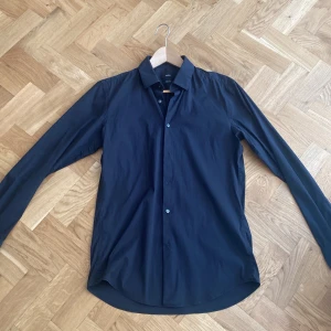 Hugo boss skjorta - Säljer nu min svarta Hugo boss skjorta som jag köpte i marbella. Skjortan köptes för 1100kr och säljs nu endast för 250kr! Skjortan är i toppskick utan defekter! Skjortan är i storlek M men passar S/M då den är slim och stretchig. 