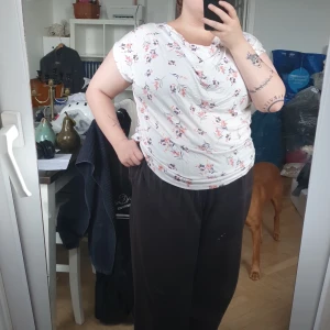 Blommig vit topp - Har tyg som automatiskt rynkar sig där fram (enligt design)