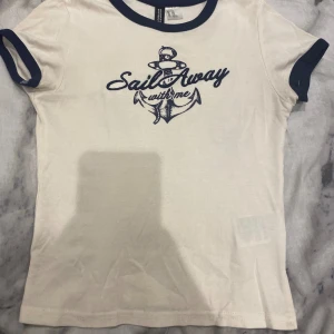 T-shirt - I bra skick och har inte varit använd ofta. Kvalitén är väldigt god, det är en krämvit T-shirt med marinblå text. Storlek: XXS. Den sitter perfekt.