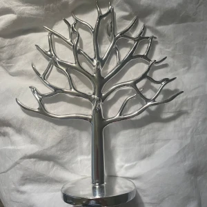 Smyckesträd  - Säljer ett silvrigt smyckesträd då det inte kommer till användning. Jättebra skick och inga defekter!  Vet inte vart det kommer ifrån. 