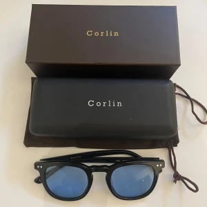 Corlin solglasögon  - Säljer dessa feta glasögon med blått glas modellen heter May.  Nypris: 1299kr Skick: 8/10