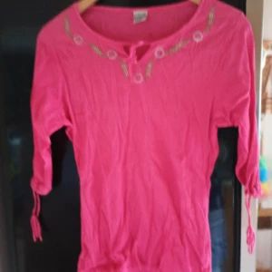 Rosa blus med broderier fram.stl M/L. - Rosa blus med snörning och broderier fram samt snörning på ärmarna.stl M/L.märke Comfort Fashion Cellbes.