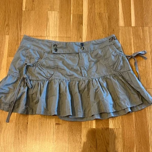 Lågmidjad kort kjol - Säljer denna superfina miniskirt då den inte passar längre! Köpt secondhand men i väldigt bra skick. Står inte storlek i men den är ca 38 cm rakt över och skulle passa någon i storlek s. Hör av dig vid fler frågor!