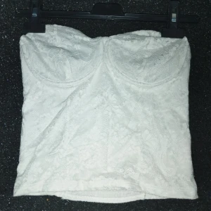 Ginatricot topp - Säljer en vit topp från Gina Tricot i storlek M. Den är i utmärkt skick och har knappt använts. Toppen är inte genomskinlig tack vare det mjuka och sköna lagret under mönstret. Tillverkad av väldigt stretchig material.