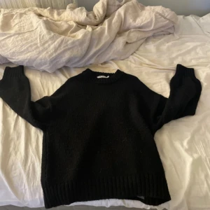 Svart stickad - Aldrig använd, därför inte tvättad och inte nopprig!!