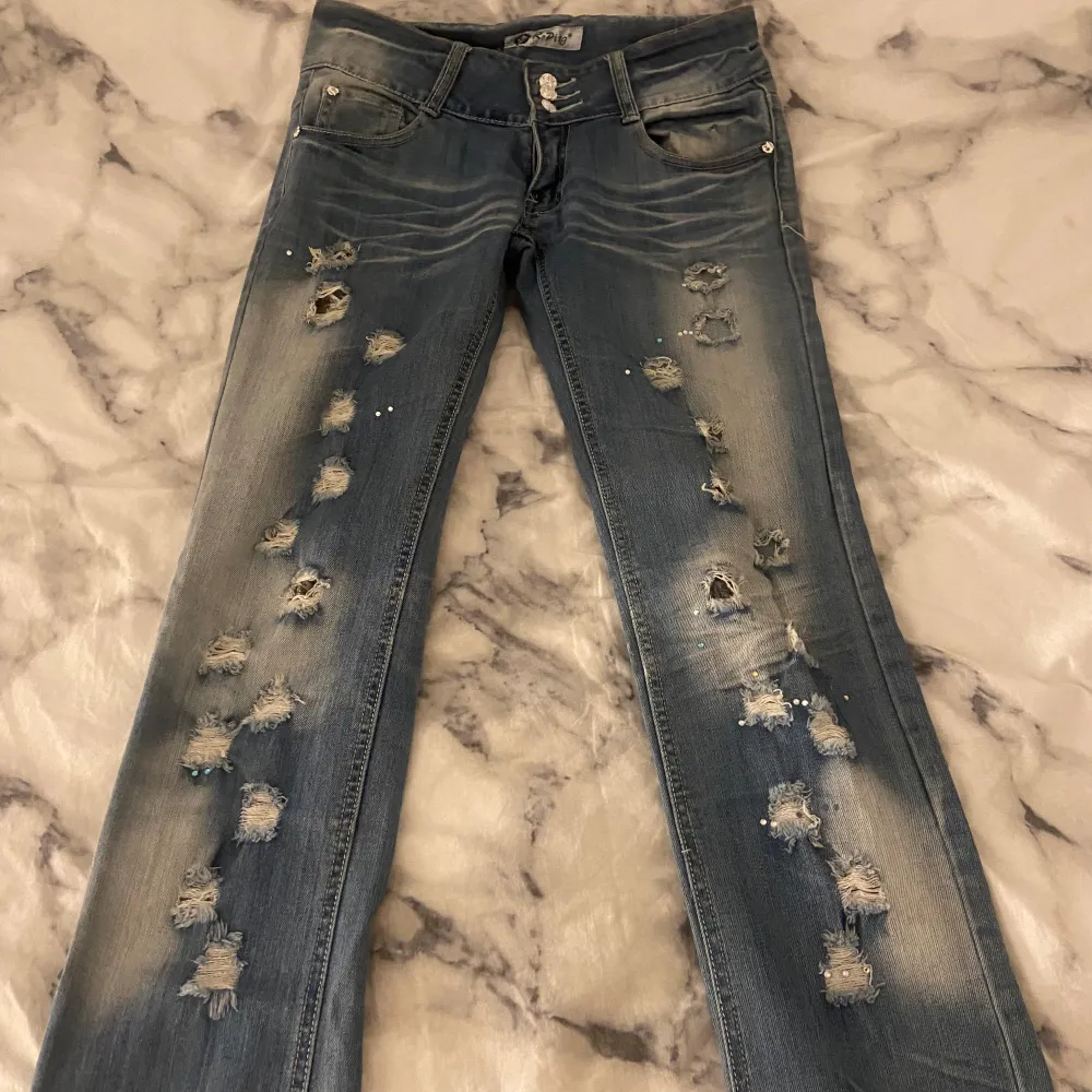Så coola jeans med slitningar, rhinestones i olika färger och har även ett blommigt innertyg som lossnat lite så man kan välja om man vill ha det eller inte, fint skick! 🤍 Skriv vid frågor osv! . Jeans & Byxor.