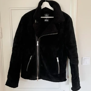 Svart shearling jacka från Jofama x King - acka från Jofamas samarbete med King, limited edition Märke: Jofama Yttermaterial: Mocka Innermaterial: Teddyfoder Storlek: 48
