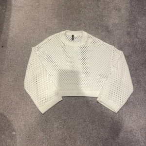 Vit långarmad, virkad tröja - Vet långarmad vit tröja med hålmönster. Helt oanvänd. Köpt på HM