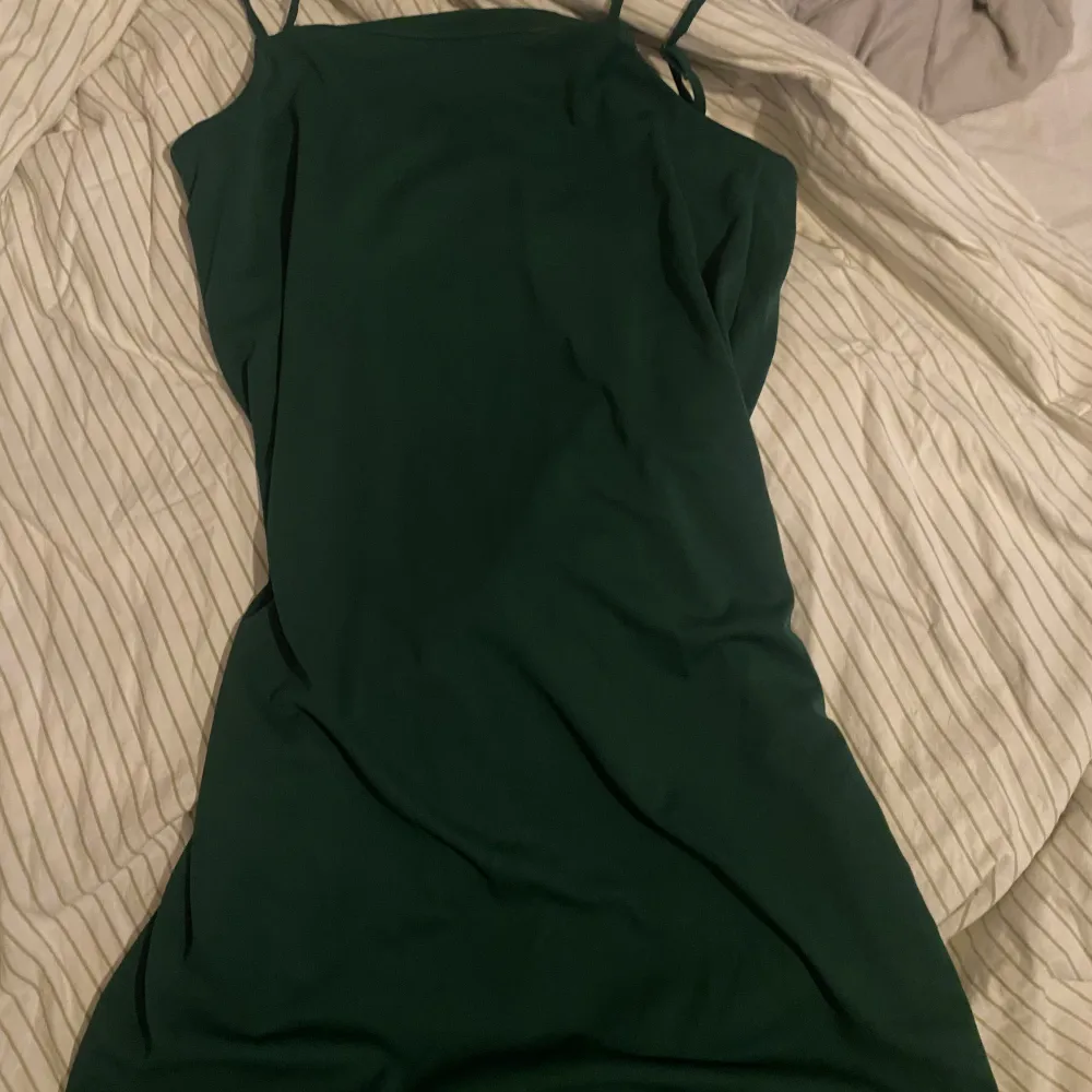 Lång grön klänning med ett slit i benet.. Klänningar.