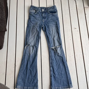 Jeans - Säljer minna högmidjade jeans med hål på båda knäna. 